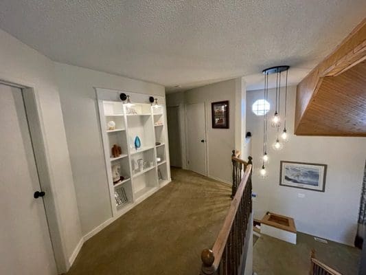 A home with a staircase and bookshelves.