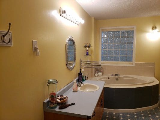 A bathroom with yellow walls and a bathtub.