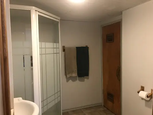 A small bathroom with a shower stall and sink.