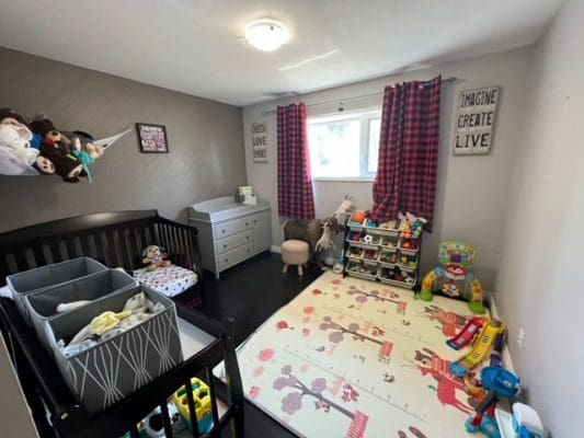A baby's room with a rug and toys.