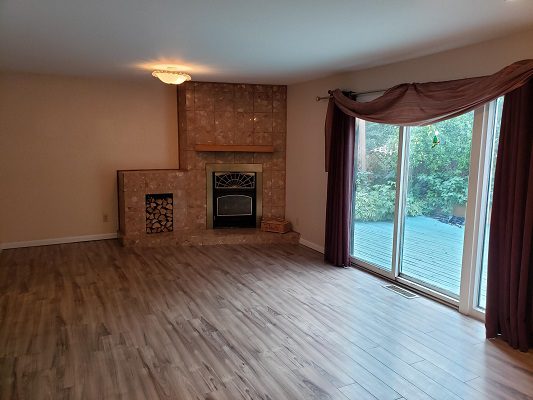 A living room with hardwood floors and a fireplace.