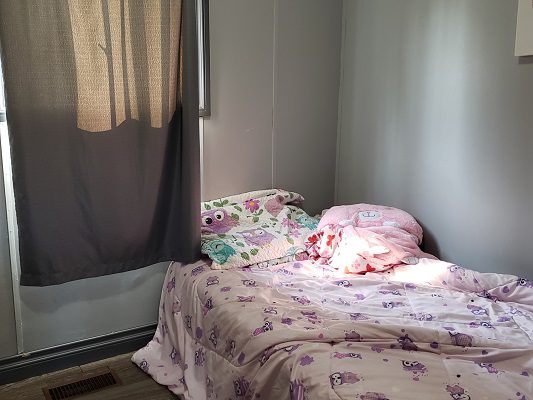 A small room with a bed and curtains.
