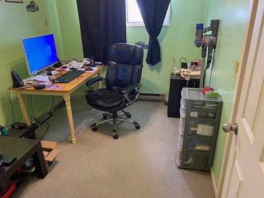 A small room with a desk, chair and computer.