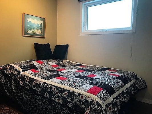 A bed in a room with a quilt on it.