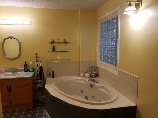 A bathroom with a jacuzzi tub and a window.