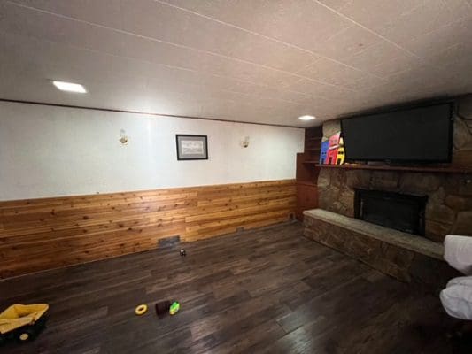 A living room with wood paneling and a tv.