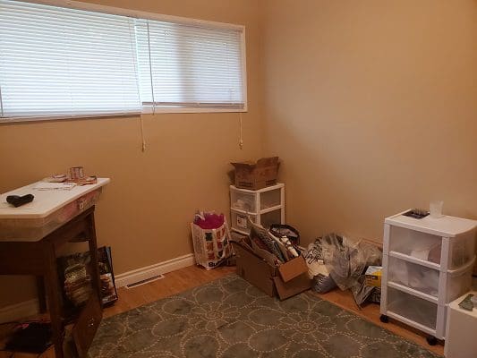 A room with a lot of clutter and a window.