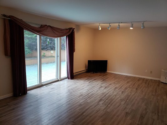 A living room with hardwood floors and a sliding glass door.