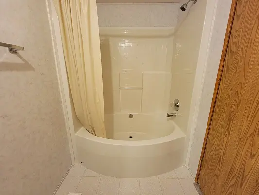 A bathroom with a bathtub and shower.