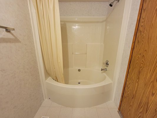 A bathroom with a bathtub and shower.