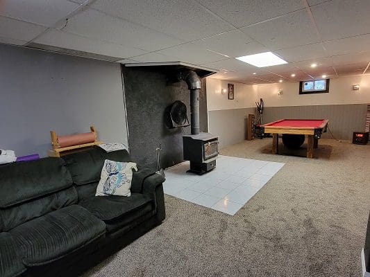 A living room with a fireplace and a pool table.