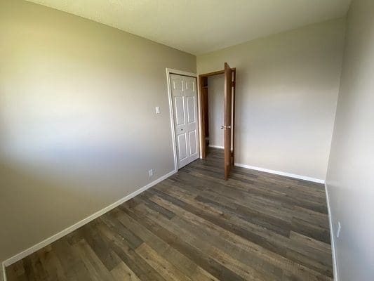 An empty room with wood floors and a door.