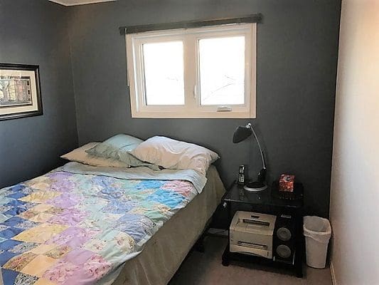 A small bedroom with a bed and a window.