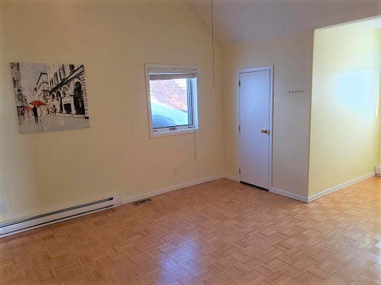 A living room with hardwood floors and a painting on the wall.