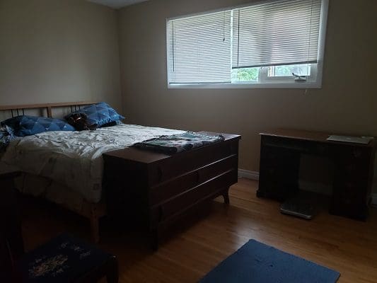 A bedroom with a bed and a desk.