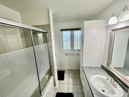 A bathroom with a sink, shower, and toilet.