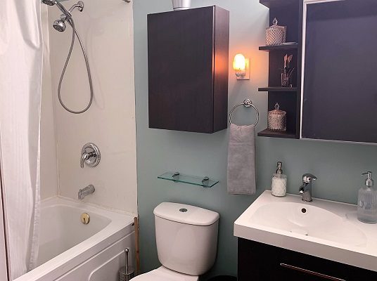 A bathroom with a toilet, shower and sink.