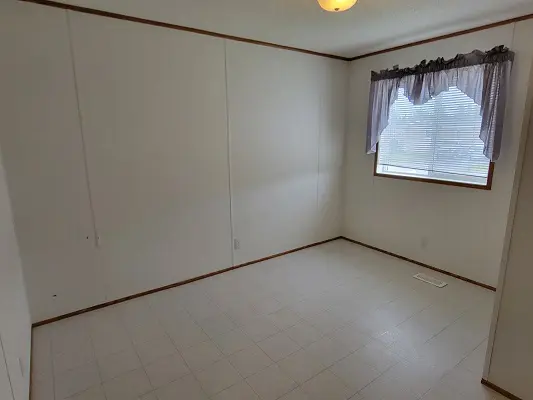An empty room with white walls and a window.