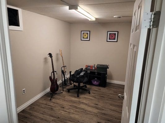 A small room with a guitar and a chair.