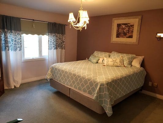 A bedroom with a bed and a chandelier.