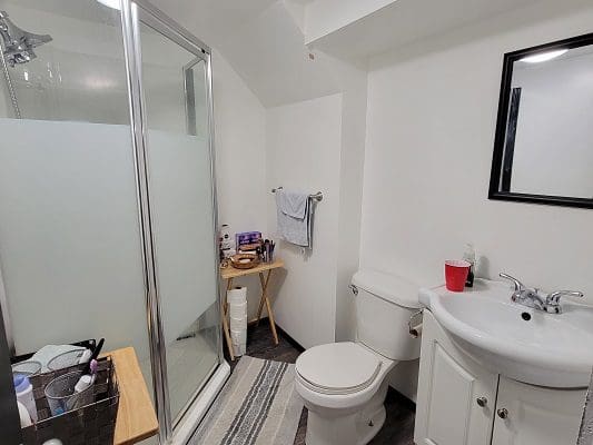 A bathroom with a toilet, sink and shower.