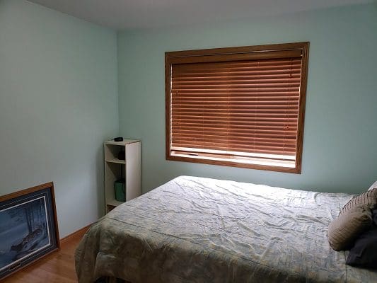 A bedroom with a bed and a picture on the wall.