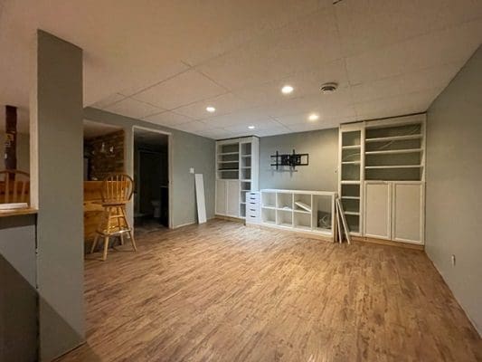 An empty living room with wood floors and a tv.