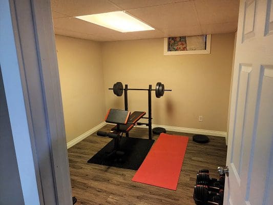 A gym room with a bench and weights.