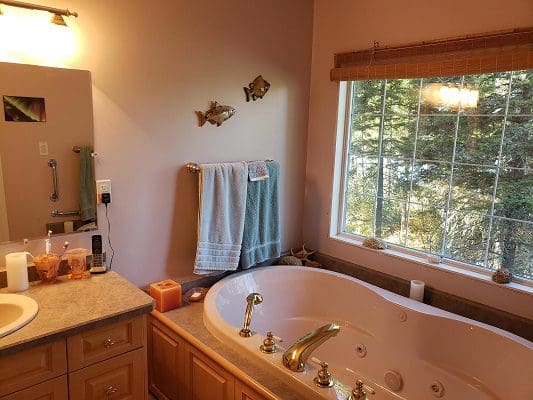 A bathroom with a jacuzzi tub and a window.