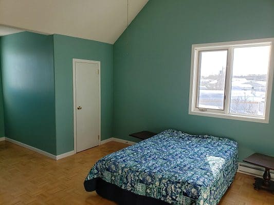 A bedroom with blue walls and a bed.