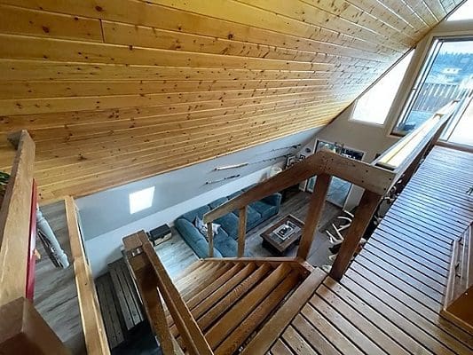 A view from the top of a wooden staircase in a home.