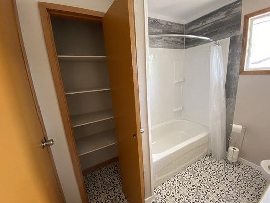 A bathroom with a toilet and a shower.