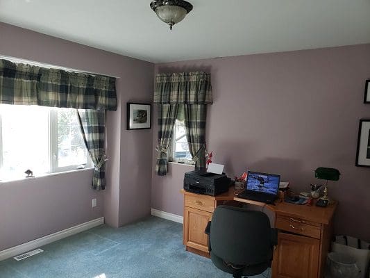 A room with purple walls and a desk.