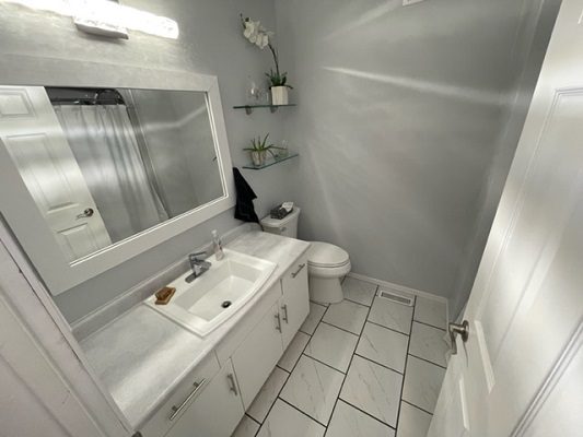 A white bathroom with a sink and mirror.