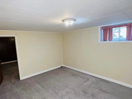 An empty room with carpet and a window.