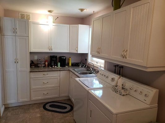 A white kitchen with a washer and dryer.