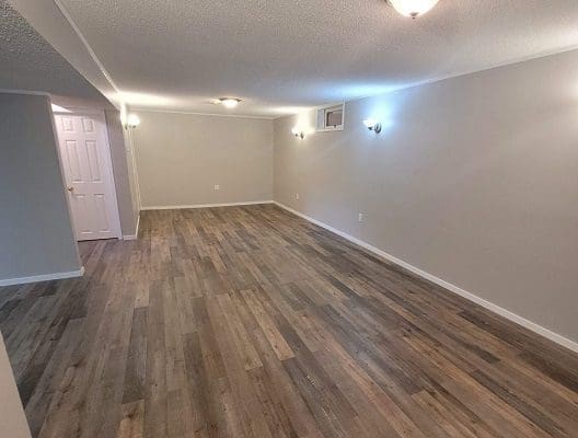Empty living room with hardwood floors.