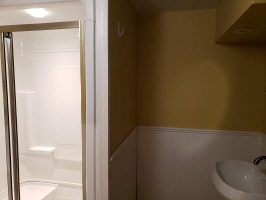 A small bathroom with a shower and sink.