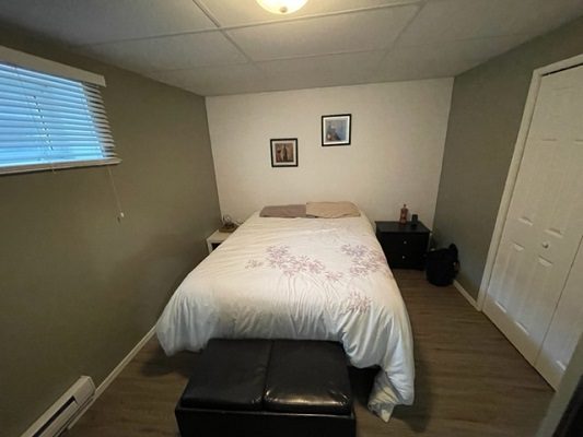 A small bedroom with a bed and a bedside table.