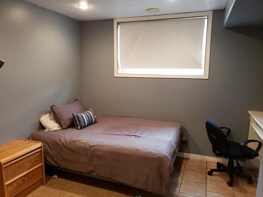 A small bedroom with a bed and a desk.