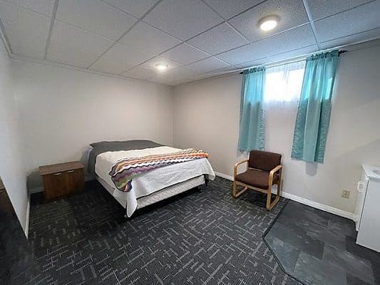 A small room with a bed and a chair.