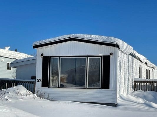 White Mobile Home Covered in Snow
