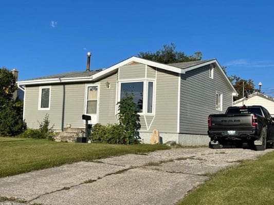 A home with a truck parked in front of it.