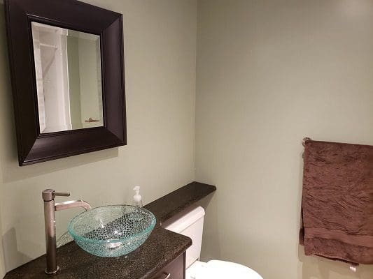 A bathroom with a sink, toilet and mirror.