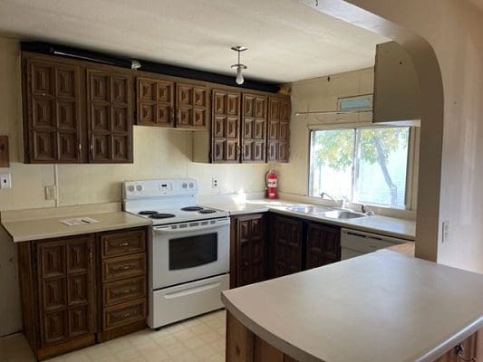 A kitchen with brown cabinets and a stove.