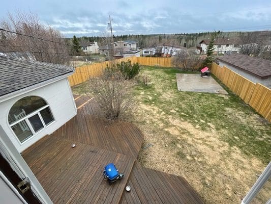 An aerial view of a backyard with a wooden deck.