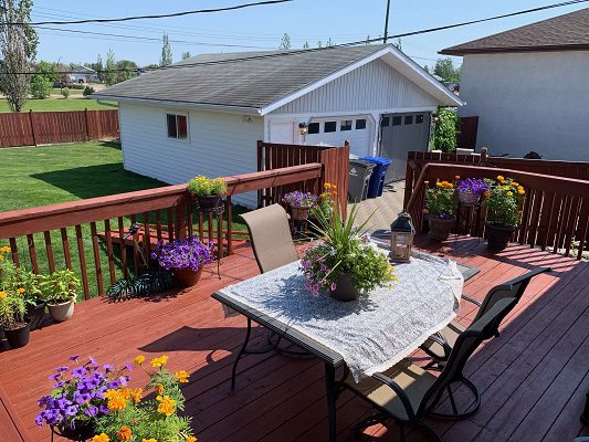 A backyard deck with a table and chairs.