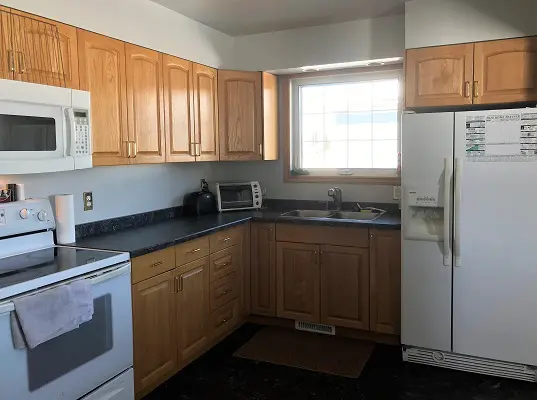 A kitchen with wood cabinets and a microwave.