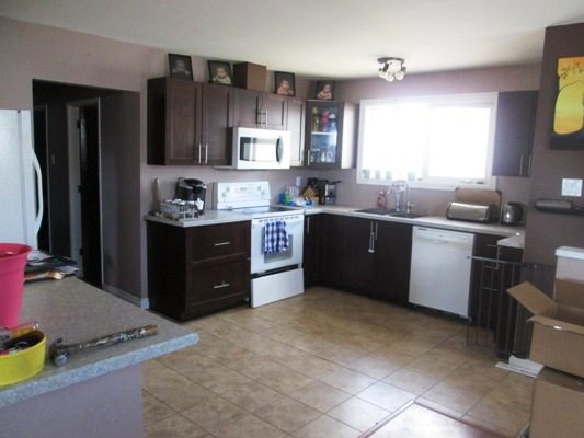 A kitchen with brown cabinets and a refrigerator.