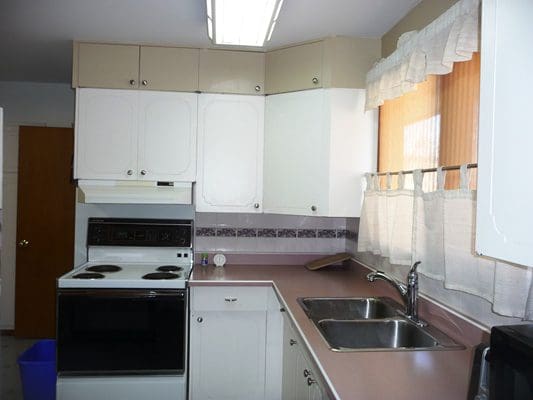 A kitchen with white cabinets and a stove.